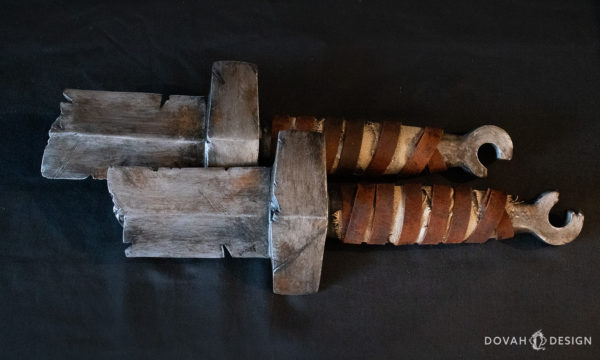 Pair of Dark Souls straight sword hilt props, photo taken from above on black background.