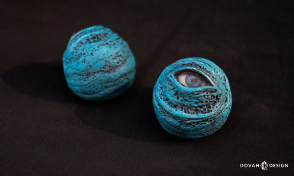 Pair of Blue Eye orbs, one facing forward, one facing backward, on a black background.