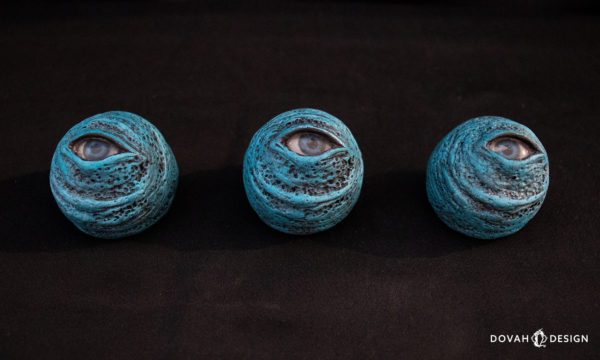 Trio of Dark Souls "Blue Eye Orbs," lined in a horizontal row looking up at the camera on a black background.