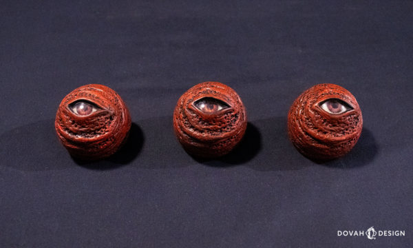 View of three red eye orbs, lined up in a row, taken from above on a black background.