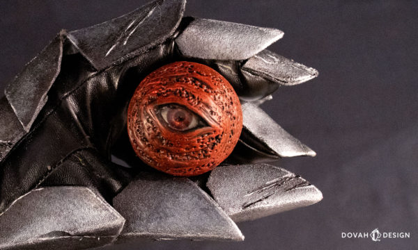 Single Red Eye Orb prop, held in a hand wearing Artorias' gauntlet.