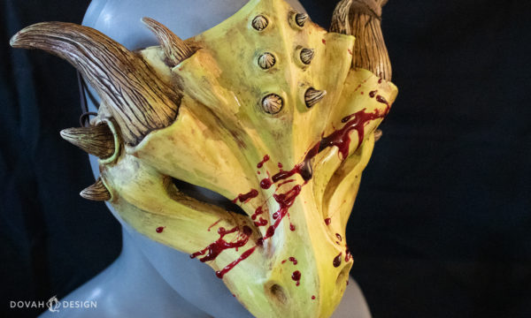 Halloween zombie dragon mask, "masquerade style," cast in yellow green urethane resin with red epoxy blood splatter, facing right on a black background with wet "blood" detail visible.