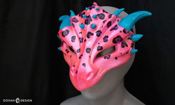 Hot pink and blue leopard spot dragon mask, inspired by Lisa Frank, facing left on black background, showing glossy hot pink finish.